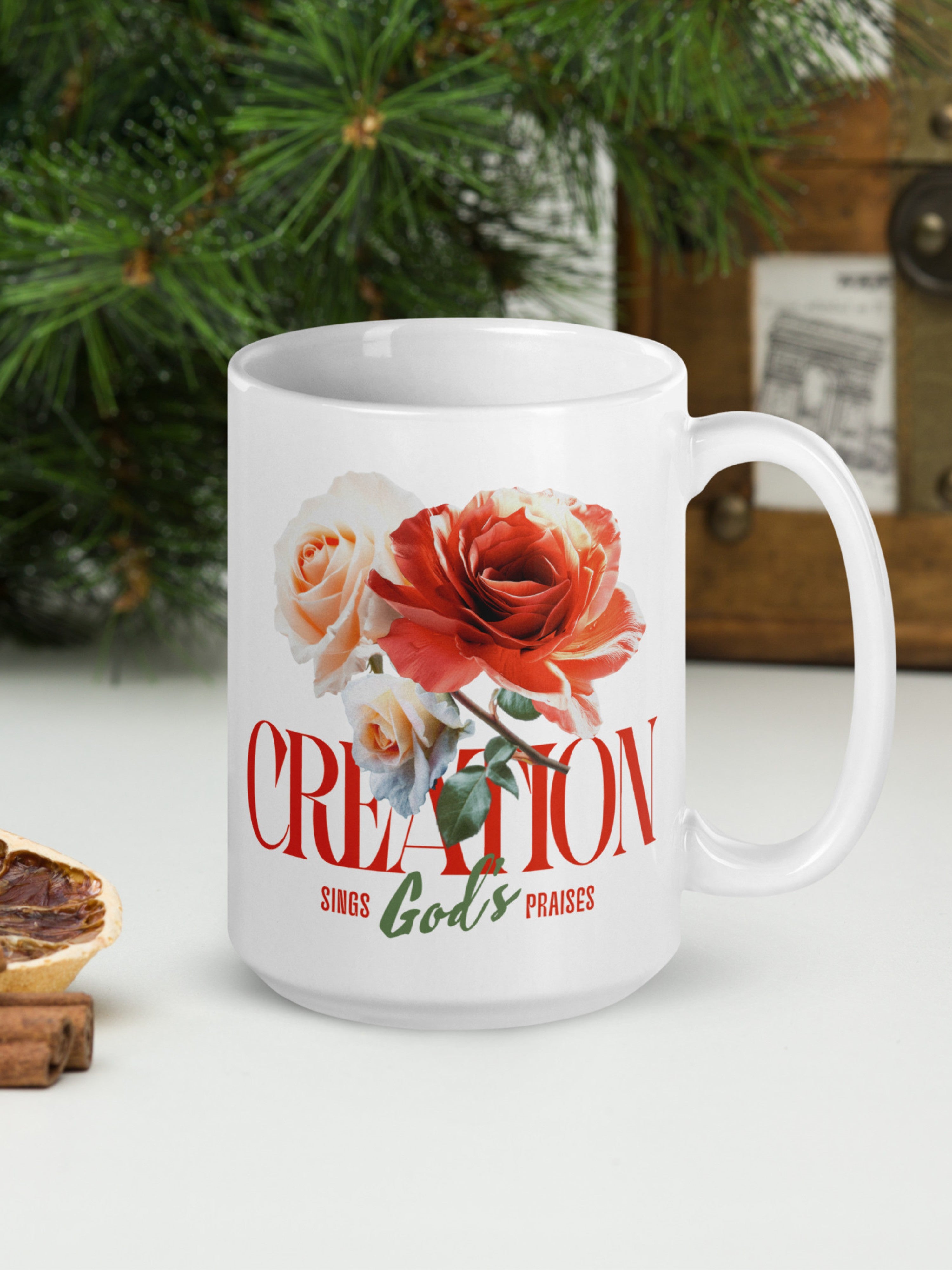 White mug with floral design and text on a white surface with Christmas decorations.